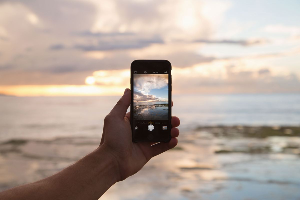 person holding smartphone showing ocean